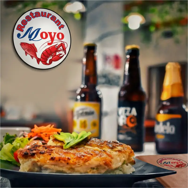 Platillo especial de filete a la plancha con aguacate y ensalada fresca servido en Restaurant Moyo en Martínez de la Torre, con bebidas de acompañamiento al fondo.