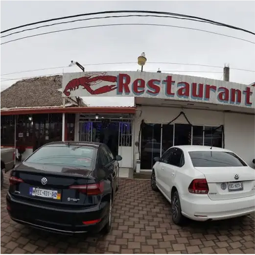 Fachada exterior de Restaurante Moyo en Martínez de la Torre con estacionamiento y letrero con langosta.