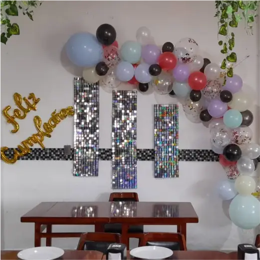 Decoración de cumpleaños con globos y paneles brillantes en el salón de eventos de Restaurante Moyo en Martínez de la Torre.