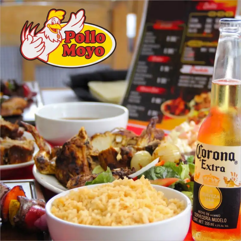 Banquete familiar de Pollo Moyo en Martínez de la Torre, mostrando pollo asado tradicional, tazón de arroz, ensalada fresca y cerveza Corona.