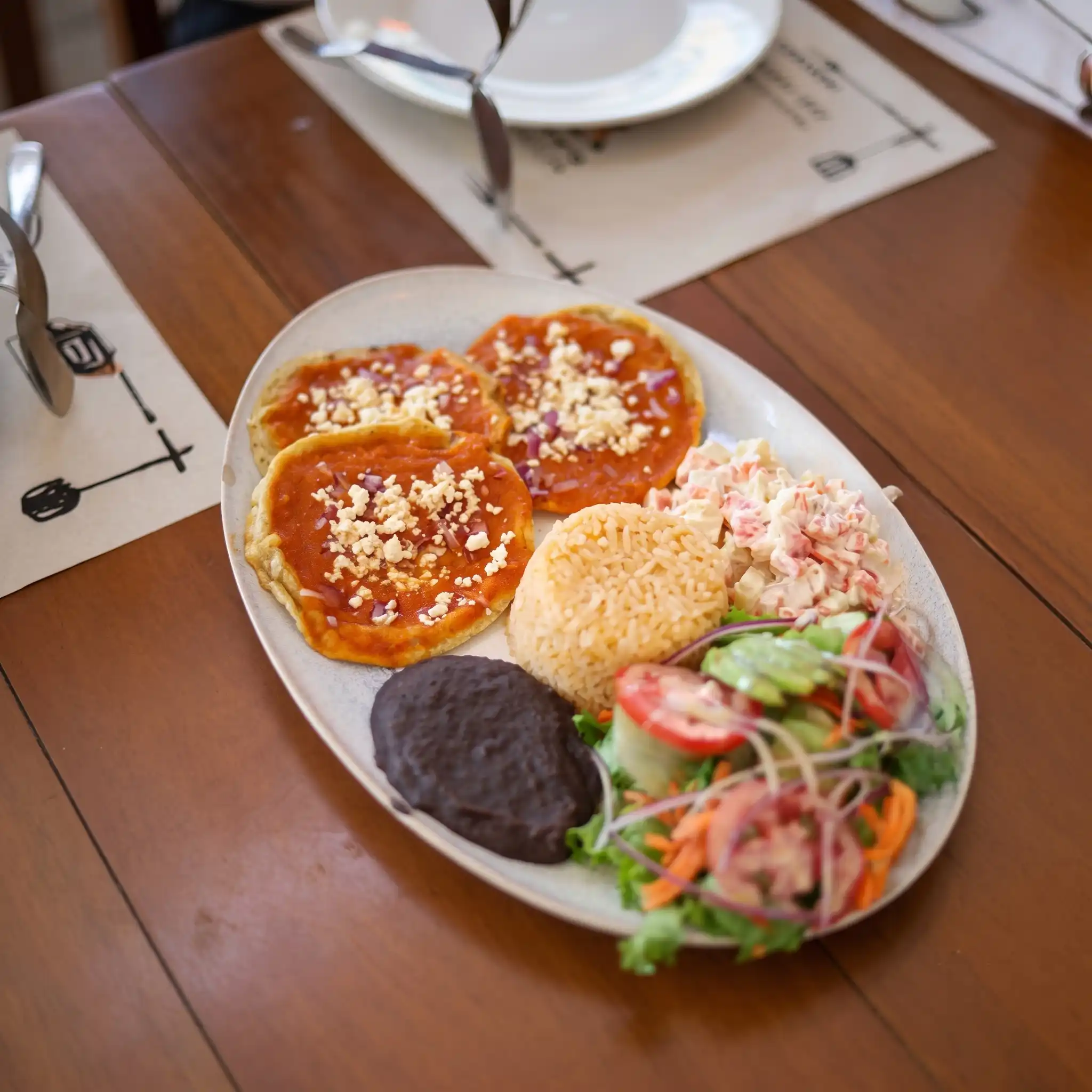 Platillo de desayuno completo con entomatadas espolvoreadas con queso, arroz, frijoles refritos y ensalada en Asadero Moyo, Martínez de la Torre.