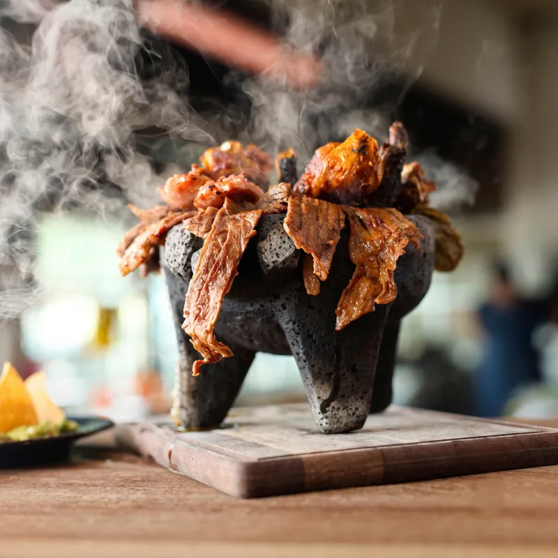 Espectacular molcajete tradicional humeante desbordante de jugosos cortes de carne asada al carbón en Asadero Moyo, Martínez de la Torre.